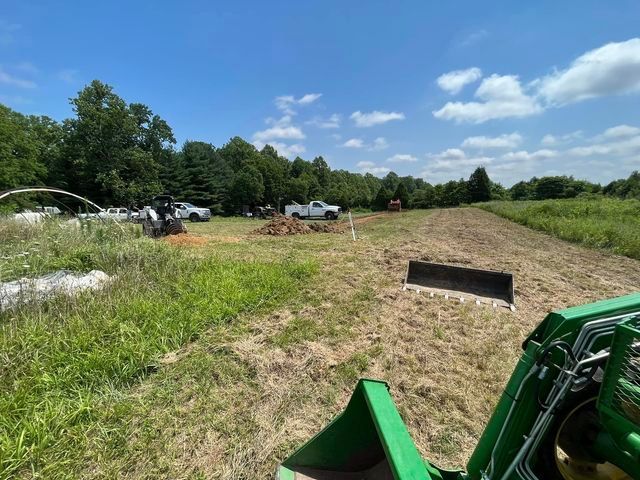 Green tractor sitting in the middle of a grassy field - Campbellsburg, IN | Twisted Electric LLC 