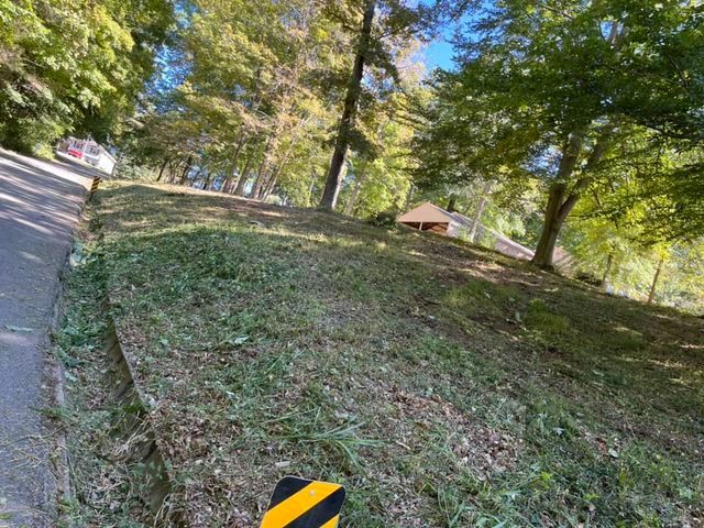 Yellow and black striped sign sitting on the side of a hill next to a road - Campbellsburg, IN | Twisted Electric LLC 