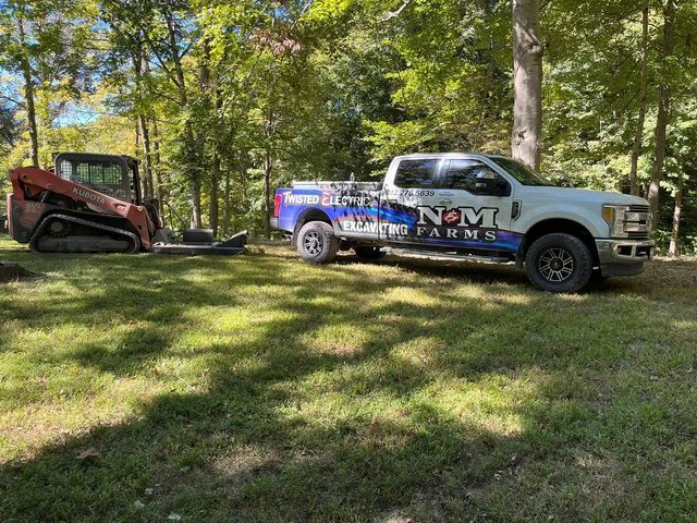 White and blue truck parked in the grass next to a bulldozer - Campbellsburg, IN | Twisted Electric LLC 