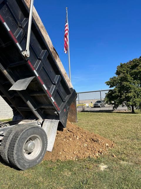 Dump truck dumping dirt in a grassy field - Campbellsburg, IN | Twisted Electric LLC 