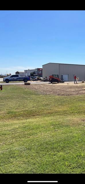 Truck parked in a grassy field in front of a building vertical - Campbellsburg, IN | Twisted Electric LLC 