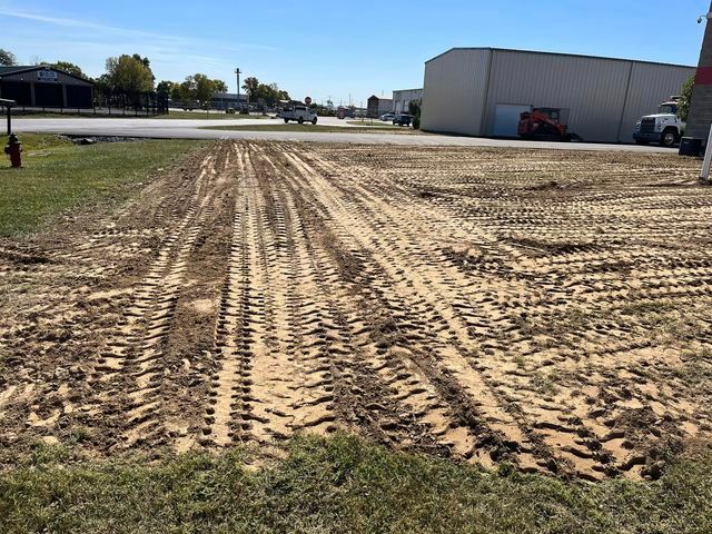 Large dirt field with tire tracks on it in front of a building - Campbellsburg, IN | Twisted Electric LLC 