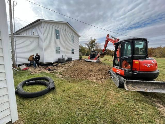 Couple of tractors digging a hole in front of a house - Campbellsburg, IN | Twisted Electric LLC 
