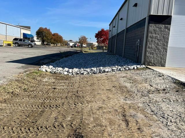 Large pile of rocks is sitting in front of a building .