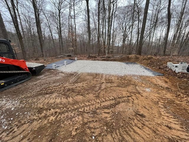 Bulldozer digging a hole in the dirt in the middle of a forest with concrete - Campbellsburg, IN | Twisted Electric LLC 