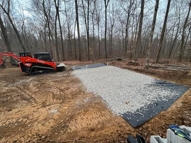 Bulldozer sitting on top of a pile of gravel in the middle of a forest - Campbellsburg, IN | Twisted Electric LLC 