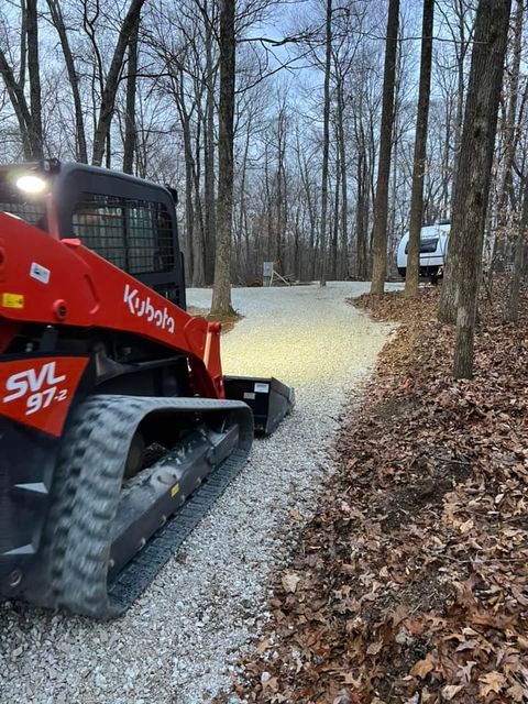 Kubota skid steer driving down a gravel road in the woods with lights - Campbellsburg, IN | Twisted Electric LLC 