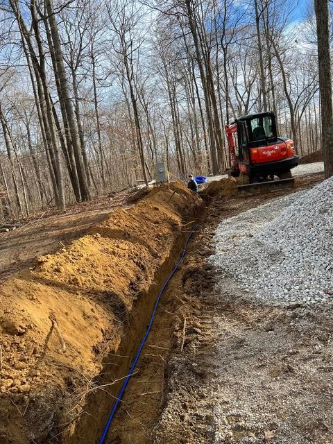 Red excavator digging a trench in the woods with gravel - Campbellsburg, IN | Twisted Electric LLC 