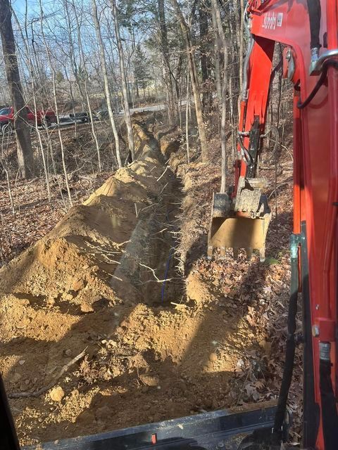 Red excavator digging a trench in the woods - Campbellsburg, IN | Twisted Electric LLC 