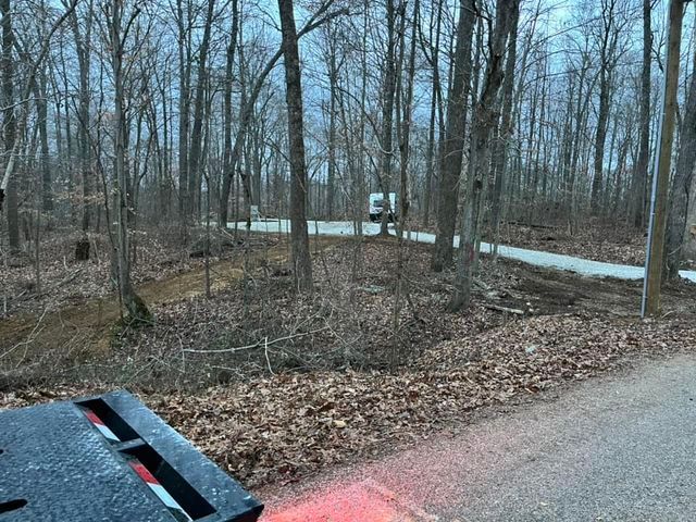 Truck driving down a road in the woods with reflection - Campbellsburg, IN | Twisted Electric LLC 