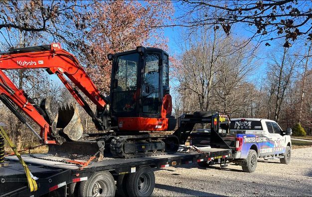 Small excavator sitting on top of a flatbed truck - Campbellsburg, IN | Twisted Electric LLC 