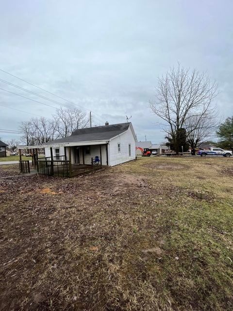 Small white house sitting in the middle of a dirt field with branch of tree - Campbellsburg, IN | Twisted Electric LLC 