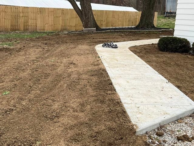 Concrete walkway being built in a backyard next to a wooden fence - Campbellsburg, IN | Twisted Electric LLC 