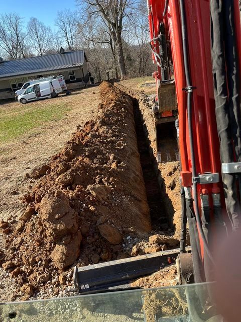 Red excavator digging a hole in the ground in front of a house - Campbellsburg, IN | Twisted Electric LLC 