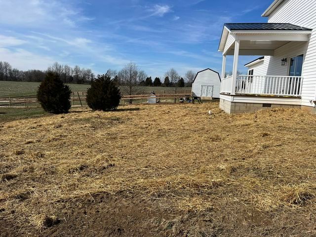 House with a porch and a lot of hay in front of it - Campbellsburg, IN | Twisted Electric LLC 
