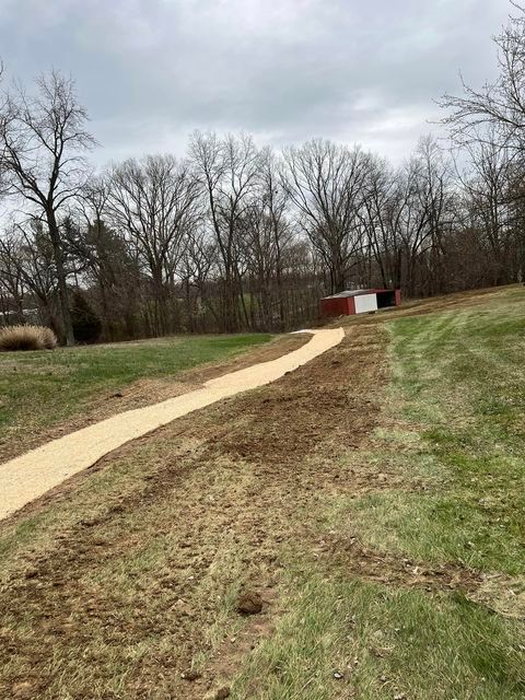 Dirt path goes through a grassy field with a red barn in the background - Campbellsburg, IN | Twisted Electric LLC 