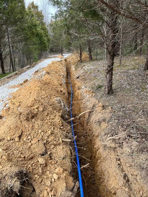 Blue pipe being installed in the dirt next to a road - Campbellsburg, IN | Twisted Electric LLC 