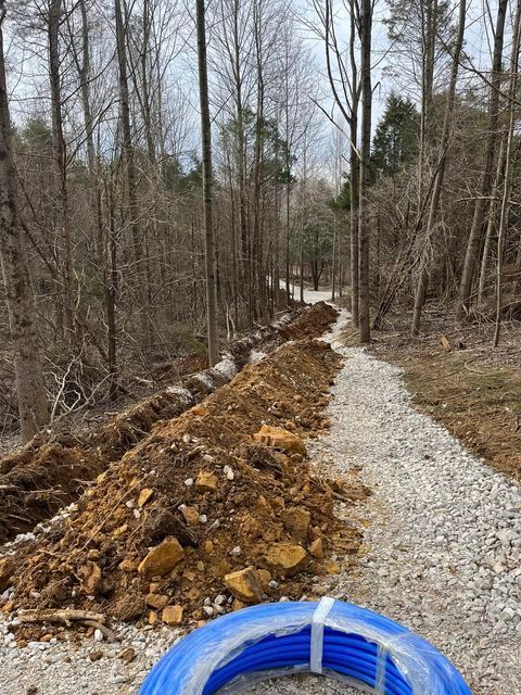 Pile of dirt and rocks on the side of a dirt road in the woods - Campbellsburg, IN | Twisted Electric LLC 
