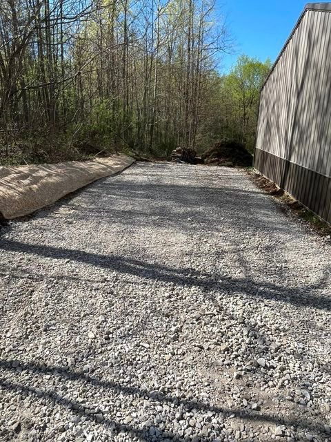 Gravel driveway leading to a building in the woods with shadow - Campbellsburg, IN | Twisted Electric LLC 