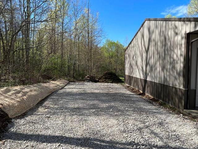 Gravel driveway leading to a building in the woods - Campbellsburg, IN | Twisted Electric LLC 