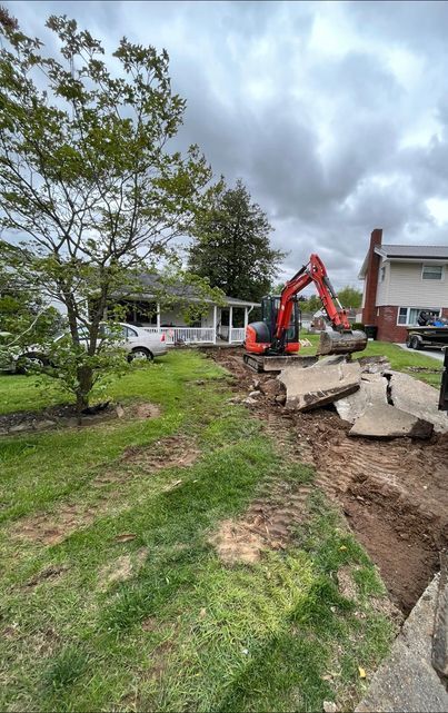 Excavator digging a hole in the grass in front of a house - Campbellsburg, IN | Twisted Electric LLC 