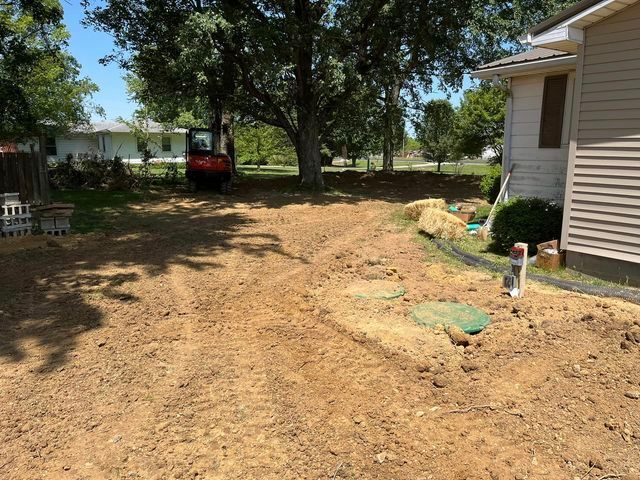 Red excavator digging in the dirt in front of a house - Campbellsburg, IN | Twisted Electric LLC 