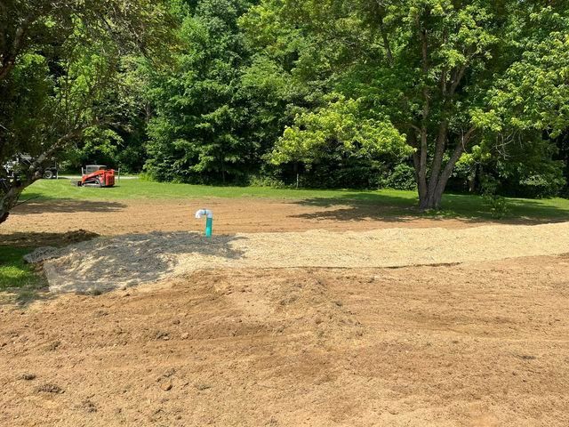 Large dirt field with trees in the background and a tractor - Campbellsburg, IN | Twisted Electric LLC 