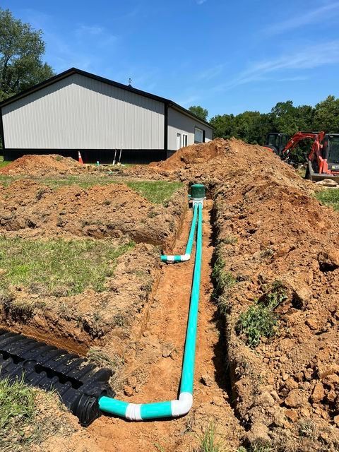 Green bent pipe being installed in the dirt in front of a house - Campbellsburg, IN | Twisted Electric LLC 