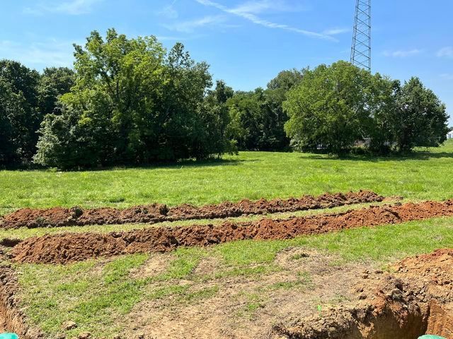 Large field of grass and dirt with a tower in the background - Campbellsburg, IN | Twisted Electric LLC 
