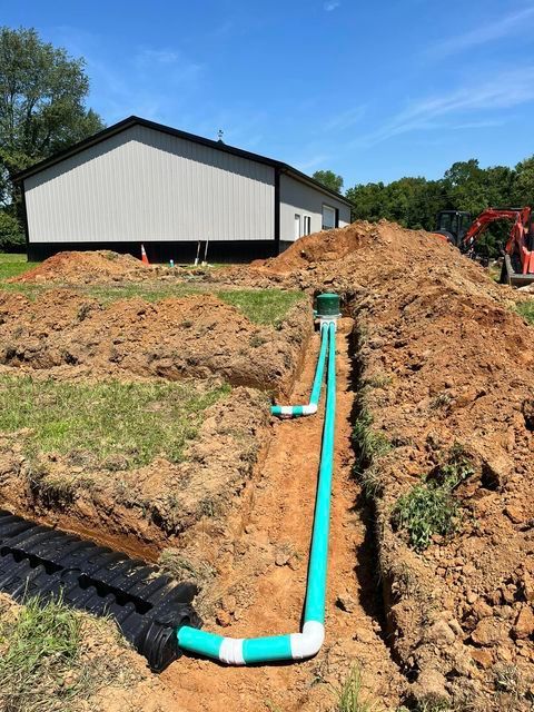 Green pipe being installed in the dirt in front of a building - Campbellsburg, IN | Twisted Electric LLC 