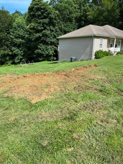 Small house on a hill with a lot of grass and dirt in front of it - Campbellsburg, IN | Twisted Electric LLC 
