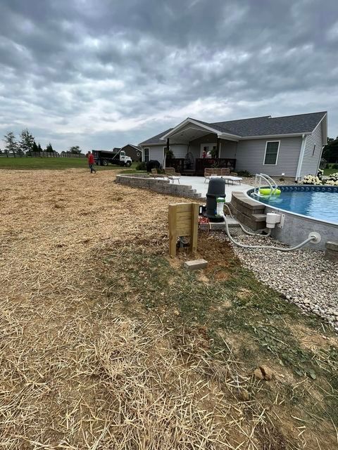 Man standing in a field next to a swimming pool in front of a house - Campbellsburg, IN | Twisted Electric LLC 
