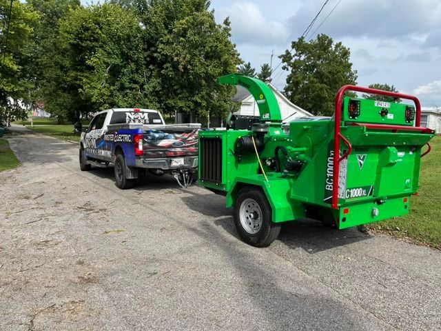 Tuck pulling a green trailer with a tree chipper attached to it - Campbellsburg, IN | Twisted Electric LLC 