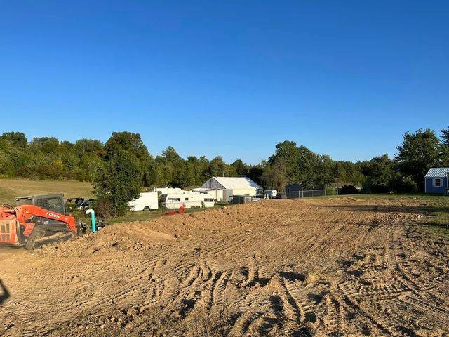 Large dirt field with a house in the background and a bulldozer in the foreground - Campbellsburg, IN | Twisted Electric LLC 