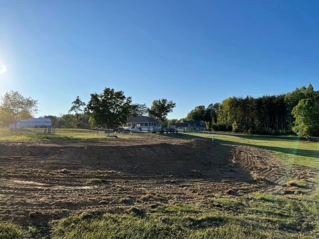 Large dirt field with a house in the background - Campbellsburg, IN | Twisted Electric LLC 
