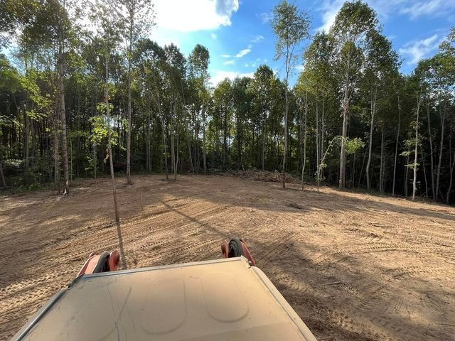 Tractor driving through a dirt field with trees in the background - Campbellsburg, IN | Twisted Electric LLC 