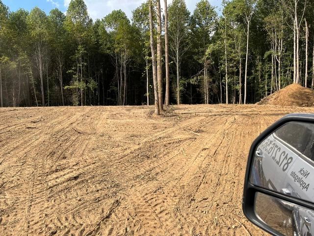 Car driving down a dirt road next to a forest - Campbellsburg, IN | Twisted Electric LLC 