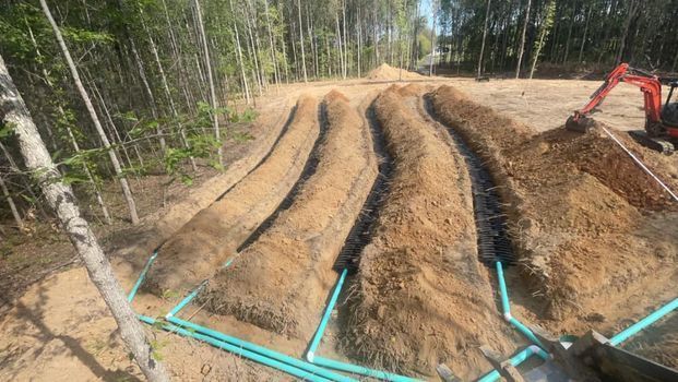 Large pile of dirt and blue pipes in the middle of a forest - Campbellsburg, IN | Twisted Electric LLC 