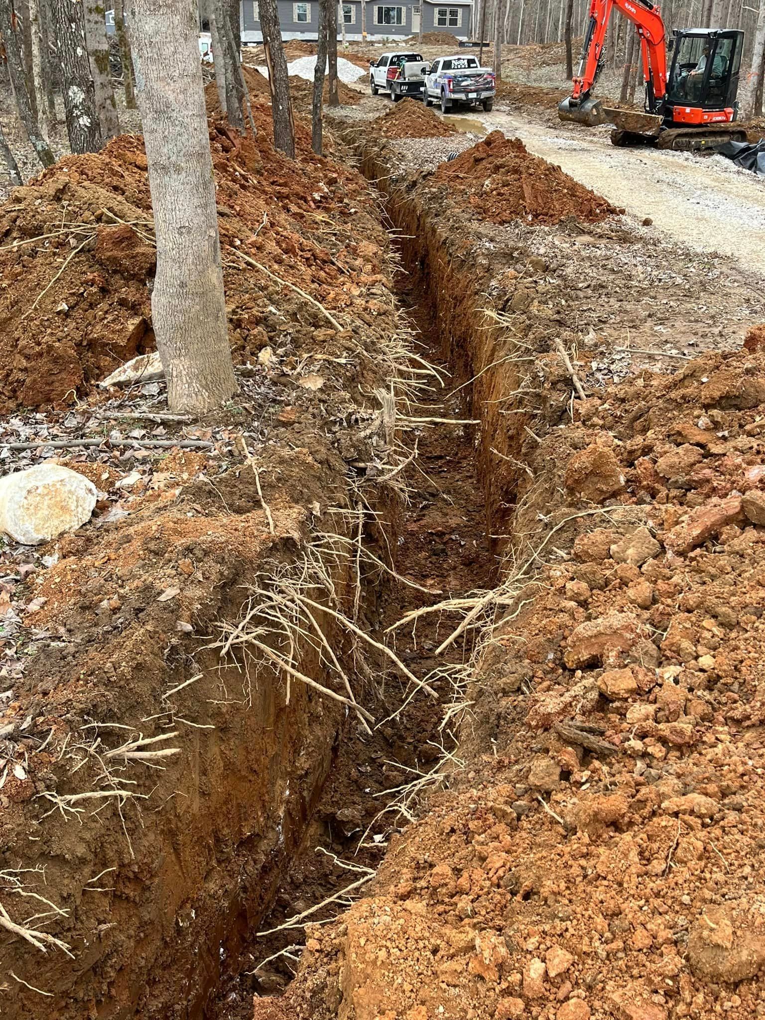 An excavator is digging a trench in the dirt next to a road | Campbellsburg, IN | Twisted Electric LLC
