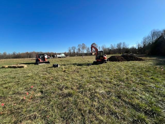 The excavator digging a hole in the middle of a grassy field - Campbellsburg, IN | Twisted Electric LLC 