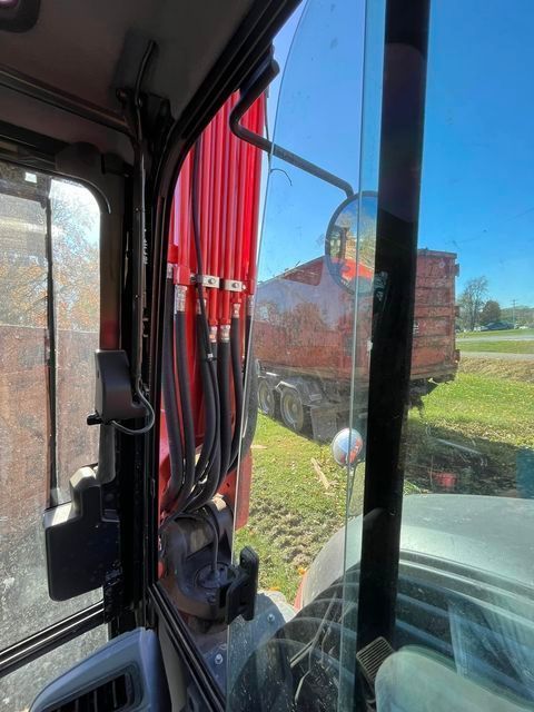 Red dump truck parked in a grassy field next to a tractor - Campbellsburg, IN | Twisted Electric LLC 