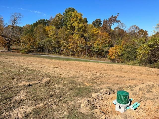 Septic tank sitting in the middle of a dirt field with a long tree shadow - Campbellsburg, IN | Twisted Electric LLC 