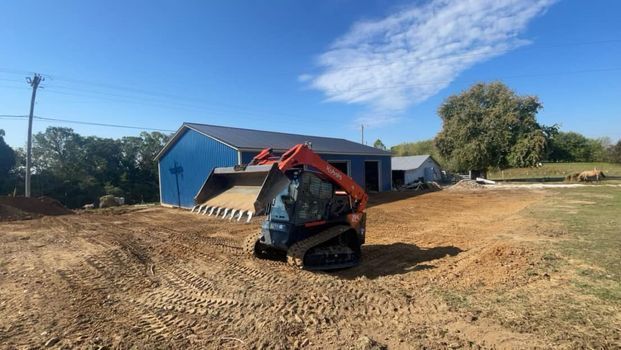 Small bulldozer sitting in a dirt field in front of a barn - Campbellsburg, IN | Twisted Electric LLC 