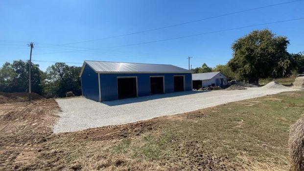 Blue garage with three garage doors sitting in the middle of a dirt field - Campbellsburg, IN | Twisted Electric LLC 