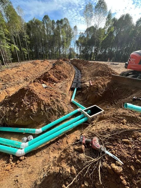 Bunch of green pipes laying in the dirt in a trench - Campbellsburg, IN | Twisted Electric LLC 