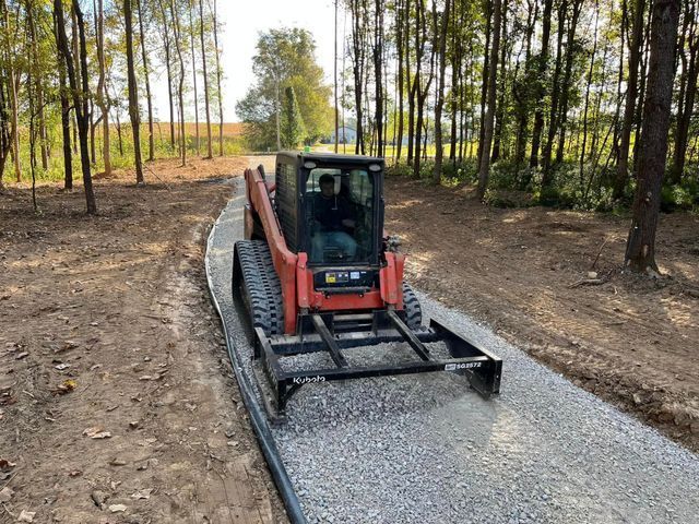 A Kubota Tractor Is Driving Down A Gravel Road — Campbellsburg, IN — Twisted Electric LLC