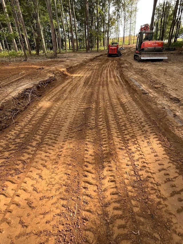 A Red Tractor Is Driving Down A Dirt Road — Campbellsburg, IN — Twisted Electric LLC