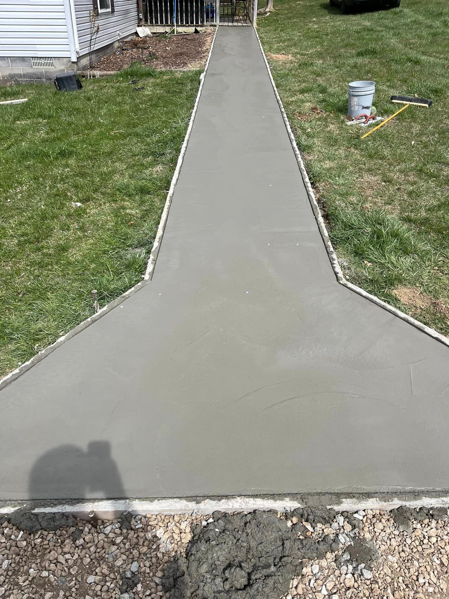A concrete walkway is being built in front of a house.