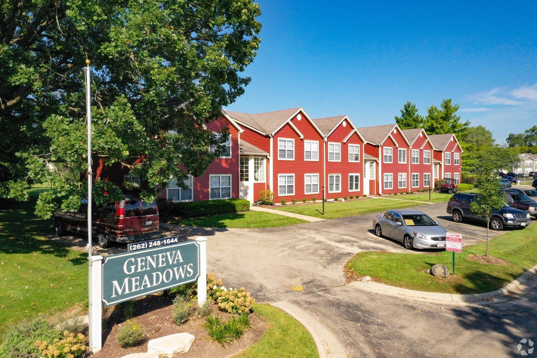 An aerial view of a red apartment building with a sign in front of it.