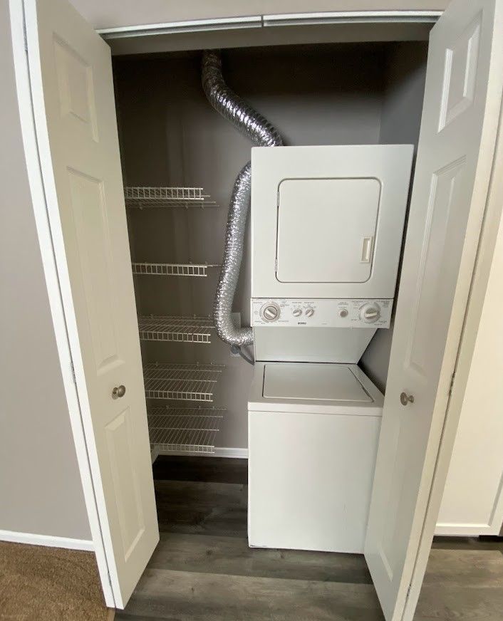 A washer and dryer are stacked on top of each other in a closet.